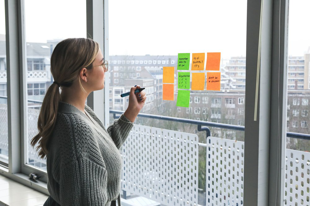 a woman writing on sticky notes.